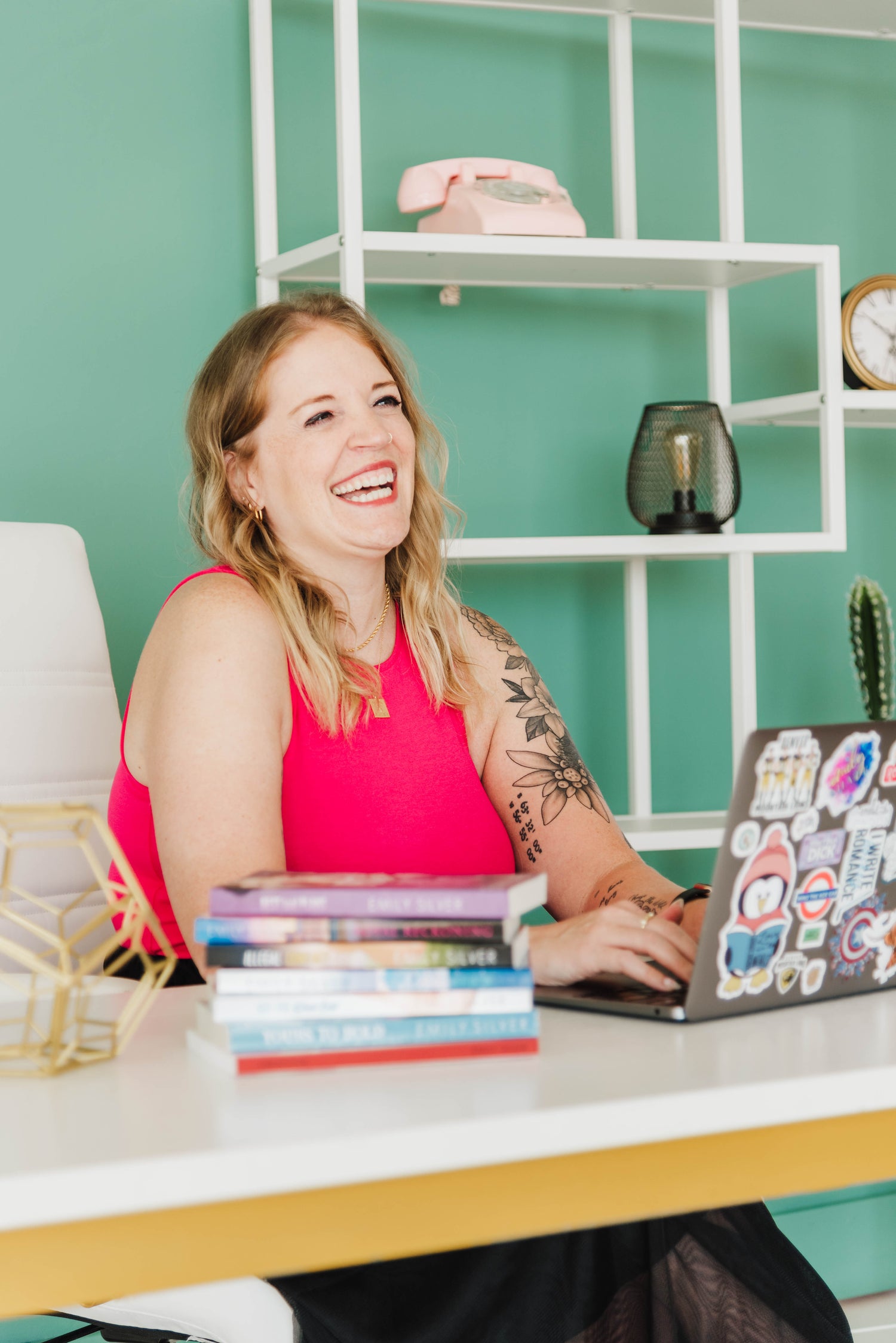 Emily Silver Headshot while laughing and typing on computer
